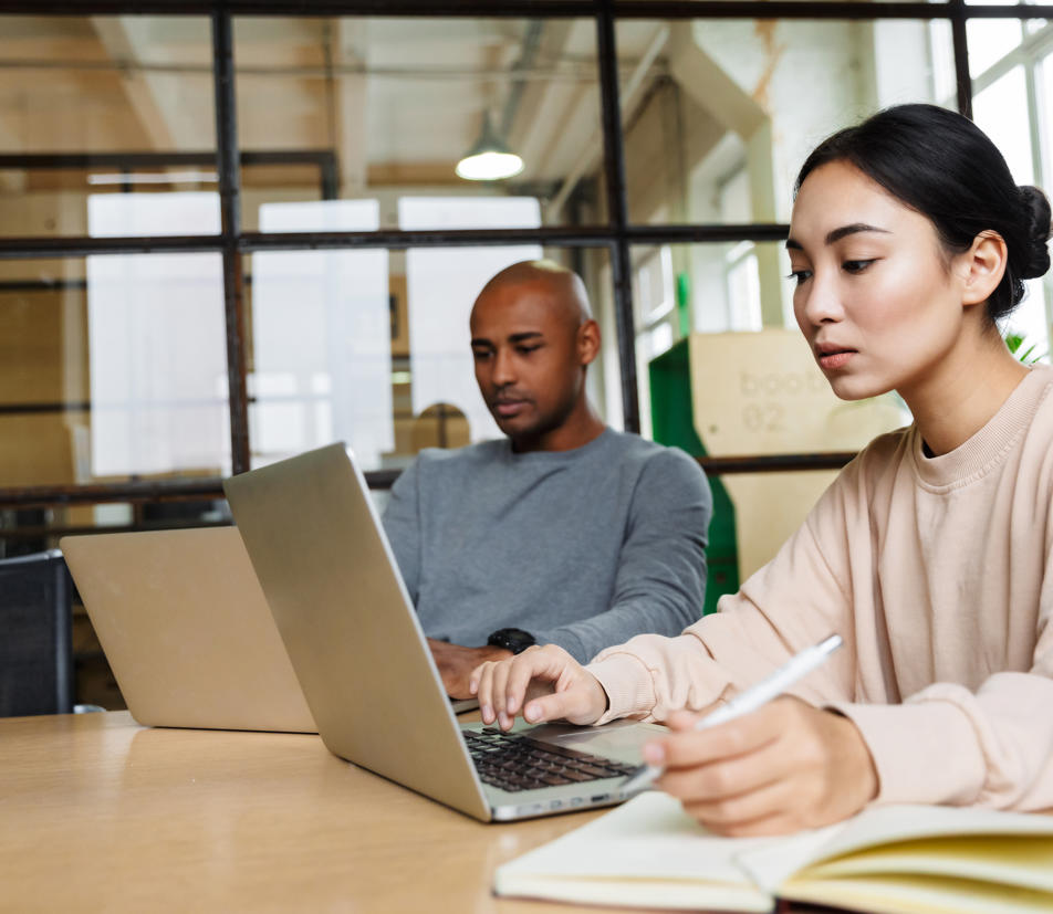 two professionals on laptops